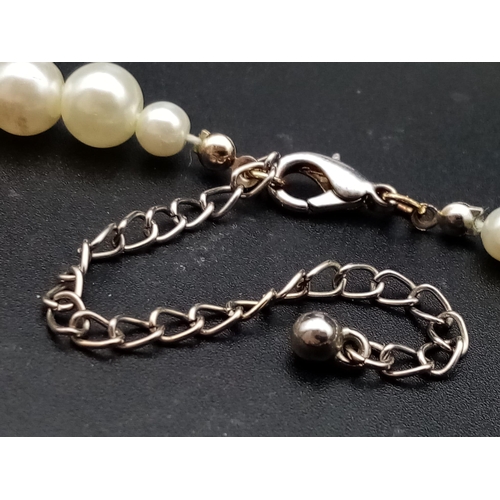 527 - A faux pearl necklace (length: 39-48 mm) AND eight expandable faux pearl bracelets.