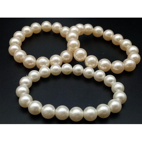 527 - A faux pearl necklace (length: 39-48 mm) AND eight expandable faux pearl bracelets.