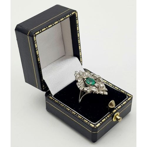 15 - An Antique Victorian 18K White Gold Emerald and Diamond Ring. A central Colombian oval cut emerald s... 