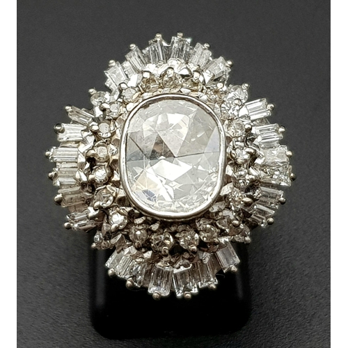 24 - A very regal diamond ring with a central oval cut diamond (approximately 2 carats) surrounded by an ... 