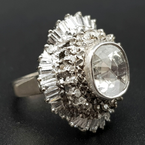 24 - A very regal diamond ring with a central oval cut diamond (approximately 2 carats) surrounded by an ... 