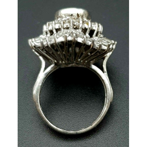 24 - A very regal diamond ring with a central oval cut diamond (approximately 2 carats) surrounded by an ... 