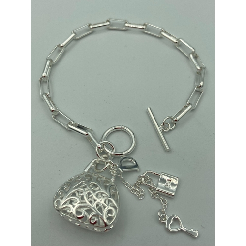 475 - Chain link BRACELET having ‘T’ bar fastening with filigree handbag pendant with padlock and key.Mark... 