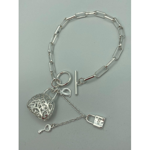 475 - Chain link BRACELET having ‘T’ bar fastening with filigree handbag pendant with padlock and key.Mark... 