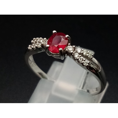 277 - A Beautiful, Understated 18K White Gold Ruby and Diamond Ring. A central oval clean faceted ruby wit... 