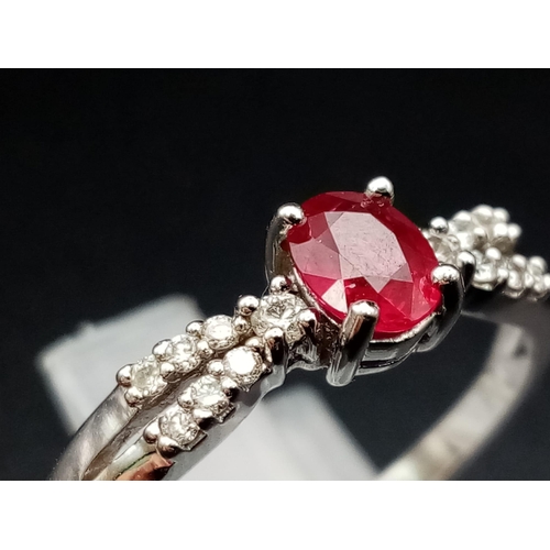 277 - A Beautiful, Understated 18K White Gold Ruby and Diamond Ring. A central oval clean faceted ruby wit... 