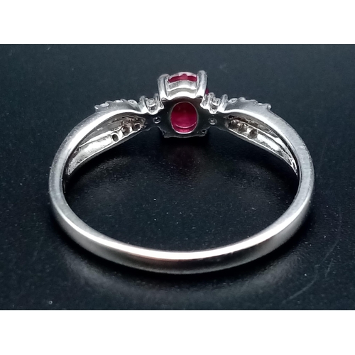 277 - A Beautiful, Understated 18K White Gold Ruby and Diamond Ring. A central oval clean faceted ruby wit... 