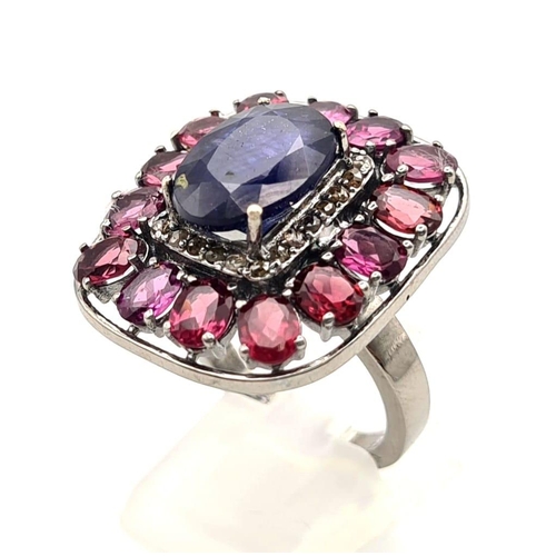 303 - A 5.75ct Blue Sapphire Ring with 5.30ct Rhodolite Gemstones set in 925 Silver. Size N. 11.26g total ... 