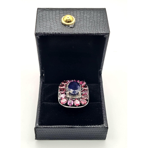 303 - A 5.75ct Blue Sapphire Ring with 5.30ct Rhodolite Gemstones set in 925 Silver. Size N. 11.26g total ... 