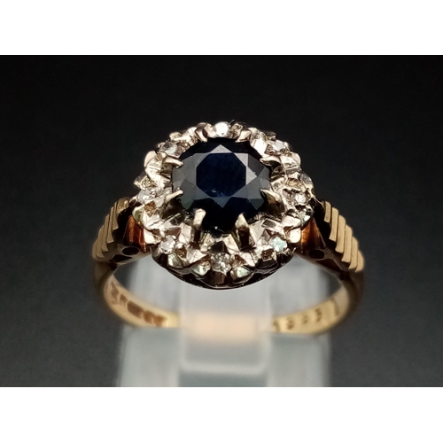 592 - A Vintage 9K Yellow Gold Sapphire and Diamond Ring. Central blue sapphire with an eight diamond halo... 