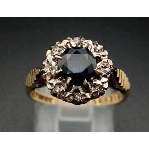 592 - A Vintage 9K Yellow Gold Sapphire and Diamond Ring. Central blue sapphire with an eight diamond halo... 