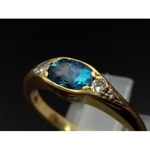 600 - An 18K Yellow Gold Ceylon Pale Blue Sapphire Diamond Ring. Central sapphire with two graduated round... 