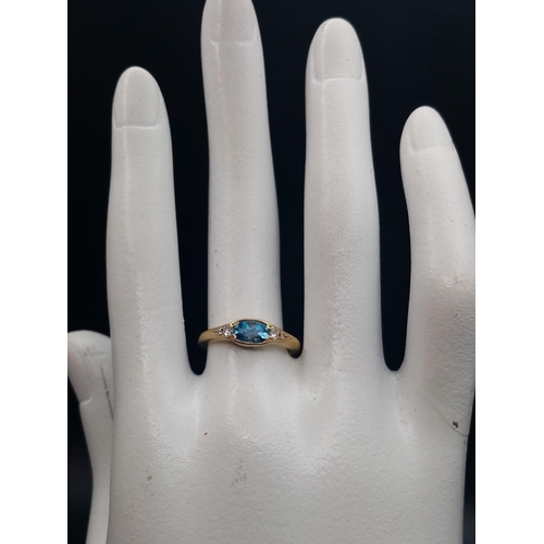 600 - An 18K Yellow Gold Ceylon Pale Blue Sapphire Diamond Ring. Central sapphire with two graduated round... 