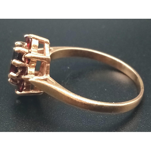 669 - A Vintage 9K Yellow Gold Garnet Ring. Central garnet oval stone surrounded by a halo of smaller garn... 