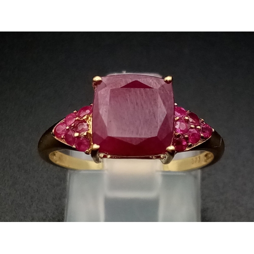 683 - A 9K Yellow Gold Ruby Ring. Central square-cut ruby with six smaller rubies either side. size P. 2.5... 