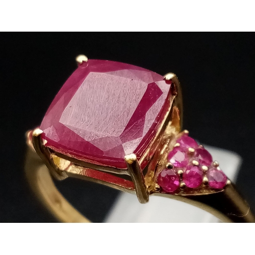 683 - A 9K Yellow Gold Ruby Ring. Central square-cut ruby with six smaller rubies either side. size P. 2.5... 