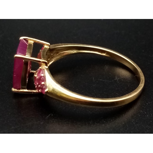 683 - A 9K Yellow Gold Ruby Ring. Central square-cut ruby with six smaller rubies either side. size P. 2.5... 