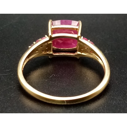 683 - A 9K Yellow Gold Ruby Ring. Central square-cut ruby with six smaller rubies either side. size P. 2.5... 