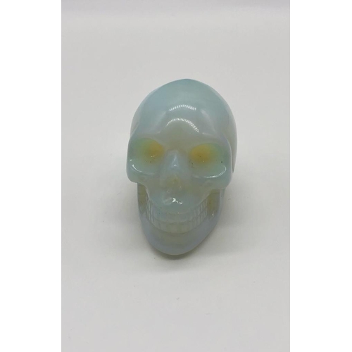 159 - A Fire Opalite Hand-Carved Skull Figure. A perfect small ornament or paperweight. 5 x 4 cm.