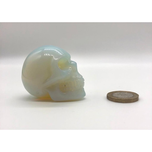 159 - A Fire Opalite Hand-Carved Skull Figure. A perfect small ornament or paperweight. 5 x 4 cm.