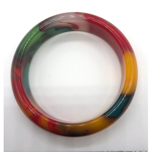 286 - A Multi-Coloured Jade Bangle. 6cm inner diameter.