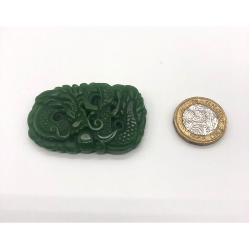 395 - A Green Jade Dragon Carved Pendant. 5 x 3cm