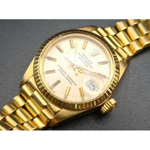 74 - An 18K Gold Rolex Oyster Perpetual Ladies Watch. Gold strap and case - 26mm. White dial with date wi... 