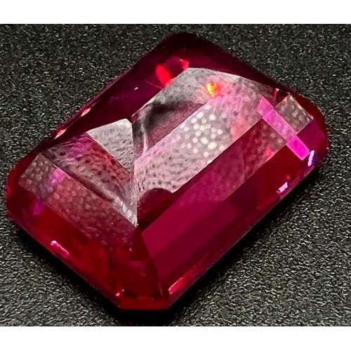 105 - A wonderful, large (57,06 carats), pinkish red RUBY. Emerald cut, flawless, with uniform colour dist... 