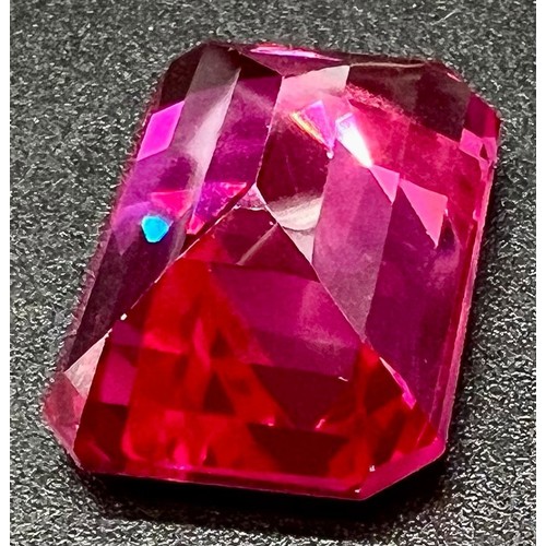 105 - A wonderful, large (57,06 carats), pinkish red RUBY. Emerald cut, flawless, with uniform colour dist... 