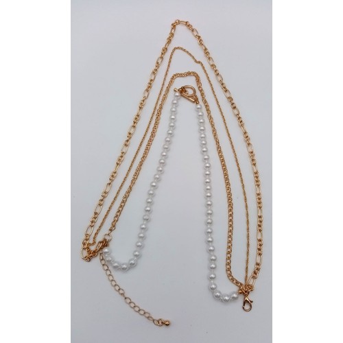 538 - A collection of two necklaces, one with faux pearls and different gold tone chains, the other one a ... 