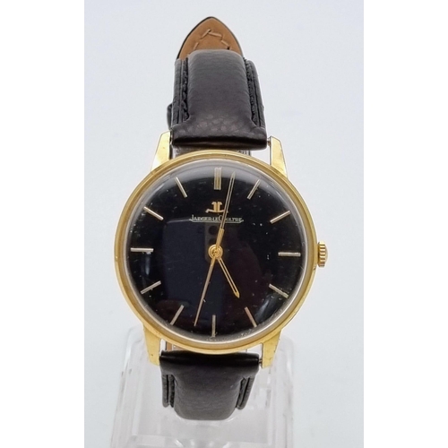 692 - A Vintage Jaeger Le Coultre 18K Gold Gents Watch. Black leather strap. Gold case - 35mm. Black dial ... 