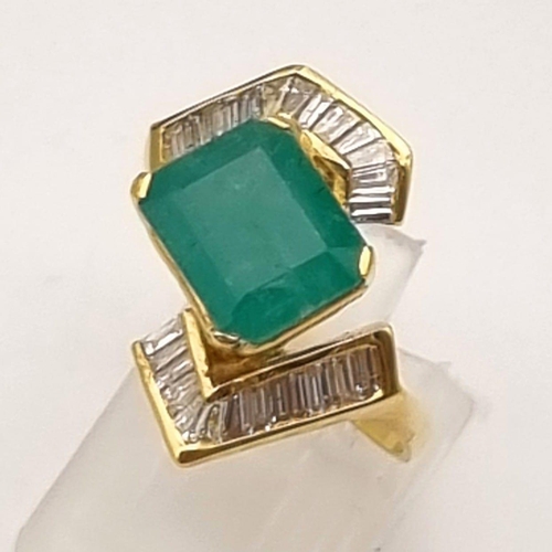 88 - An 18K Yellow Gold Emerald and Diamond Ring. Central cut natural emerald with 26 tapered baguette cu... 