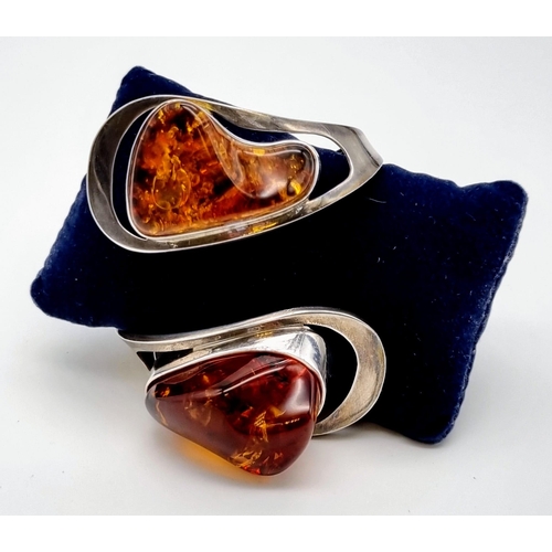 36 - A Baltic Amber Spiral Bangle Bracelet. Two irregular shaped pieces of amber add mystique to this ecl... 