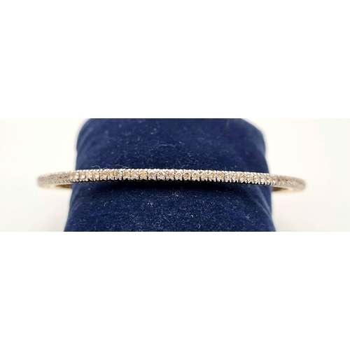 281 - A 18K GOLD AND DIAMOND SLAVE BANGLE, 12.7gms   7cms diameter