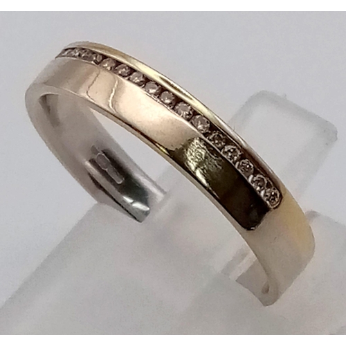 288 - AN 18K GOLD BAND RING WITH CHANNEL SET DIAMONDS.  3.1gms  size N