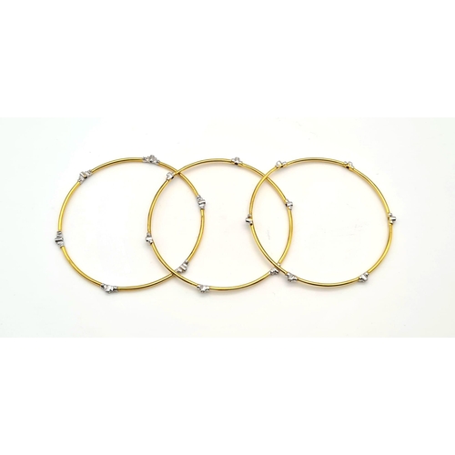 396 - A SET OF 3 DIAMOND SLAVE BANGLES IN 21K GOLD.  17.6gms