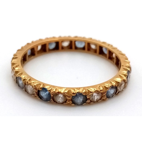 410 - AN 18K GOLD FULL ETERNITY RING WITH ATTRACTIVE BLUE AND WHITE STONES.  2.6gms  size Q