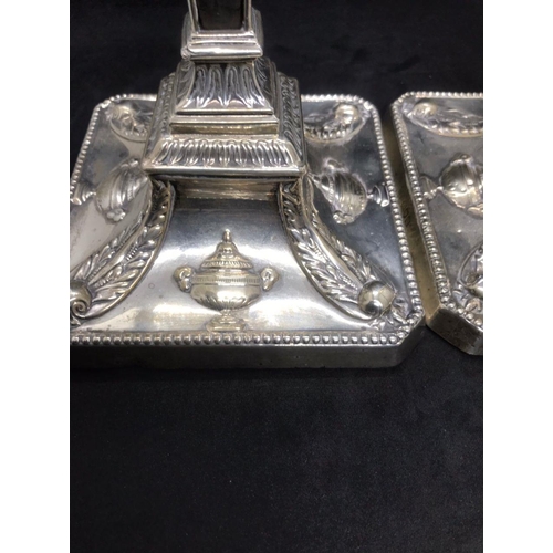 134 - A pair of early George V sterling solid silver mounted candlesticks, each with filled square base ha... 