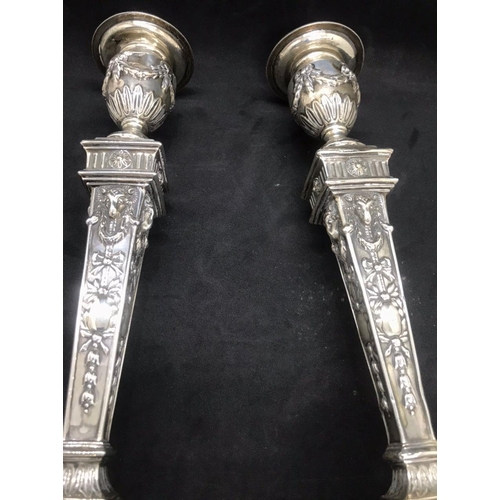 134 - A pair of early George V sterling solid silver mounted candlesticks, each with filled square base ha... 