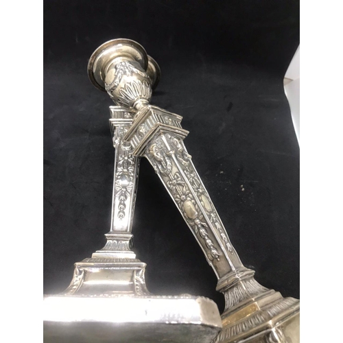 134 - A pair of early George V sterling solid silver mounted candlesticks, each with filled square base ha... 