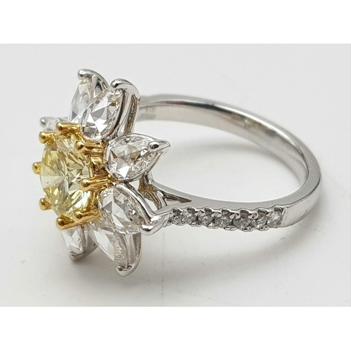 67 - A STUNNING PLATINUM RINGWITH A FANCY YELLOW DIAMOND AT THE CENTRE OF A FLORAL DESIGN SURROUNDED BY W... 