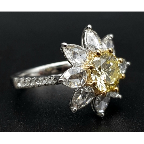 67 - A STUNNING PLATINUM RINGWITH A FANCY YELLOW DIAMOND AT THE CENTRE OF A FLORAL DESIGN SURROUNDED BY W... 