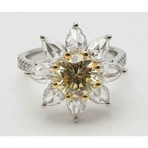 67 - A STUNNING PLATINUM RINGWITH A FANCY YELLOW DIAMOND AT THE CENTRE OF A FLORAL DESIGN SURROUNDED BY W... 