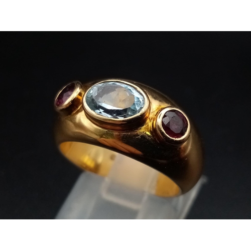 142 - AN 18K YELLOW GOLD RING WITH AQUAMARINE CENTRE STONE FLANKED EITHER SIDE BY 2 GARNETS .  9.7gms  siz... 