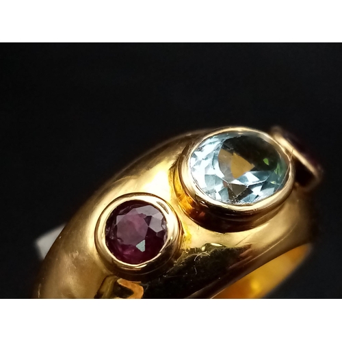 142 - AN 18K YELLOW GOLD RING WITH AQUAMARINE CENTRE STONE FLANKED EITHER SIDE BY 2 GARNETS .  9.7gms  siz... 