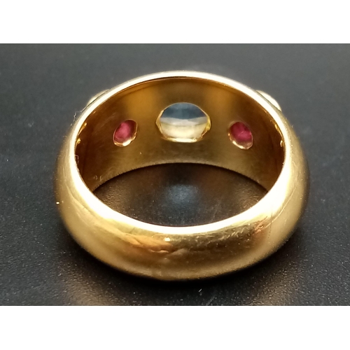 142 - AN 18K YELLOW GOLD RING WITH AQUAMARINE CENTRE STONE FLANKED EITHER SIDE BY 2 GARNETS .  9.7gms  siz... 