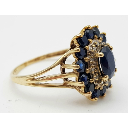 95 - A 9 K yellow gold ring with a diamond and sapphire cluster. Ring size: Q, weight: 3.2 g.