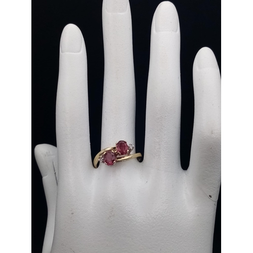 122 - A 9 K yellow gold ring with diamonds and rubies in a twisted design. Ring size: P, weight: 2.6 g.