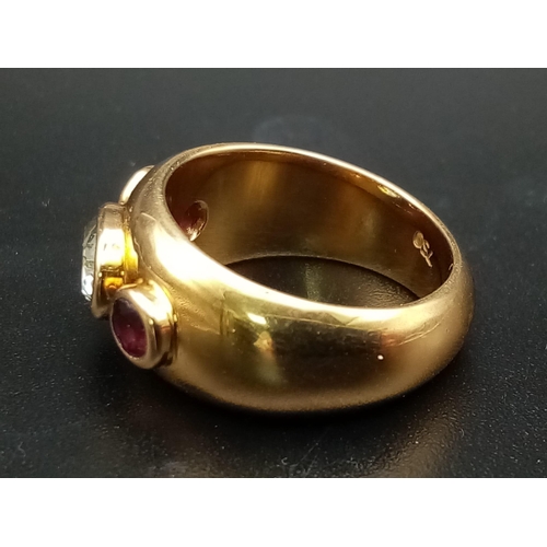 142 - AN 18K YELLOW GOLD RING WITH AQUAMARINE CENTRE STONE FLANKED EITHER SIDE BY 2 GARNETS .  9.7gms  siz... 