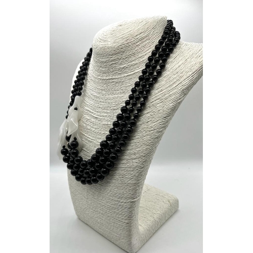 251 - A Graduated Black Onyx and White Porcelain Necklace. A mesmerising blend of onyx beads and jade flow... 